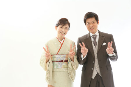 還暦スタジオで撮るご夫婦の誕生日記念写真で笑顔でピース