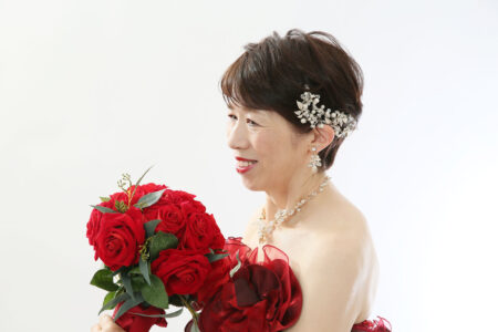 還暦の記念にバラのブーケと赤ドレスでおしゃれな雰囲気で撮影できます。