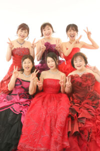 還暦のグループ記念ショットは赤ドレスをチョイス、最後はダブルピースで