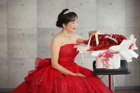 赤いドレスと、プレゼントの還暦祝いのバラのブーケがベストマッチ!